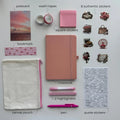 Collection of stationery items including a notebook, pens, washi tapes, and stickers on a light gray background.