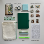 Collection of stationery items including a notebook, pen, highlighters, stickers, and pouch on a light gray background.