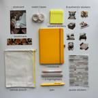 Collection of stationery items including a yellow notebook, pen, highlighters, stickers, and pouch on a gray background.