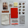 Collection of stationery items including a orange notebook, pen, highlighters, stickers, and pouch on a white background.