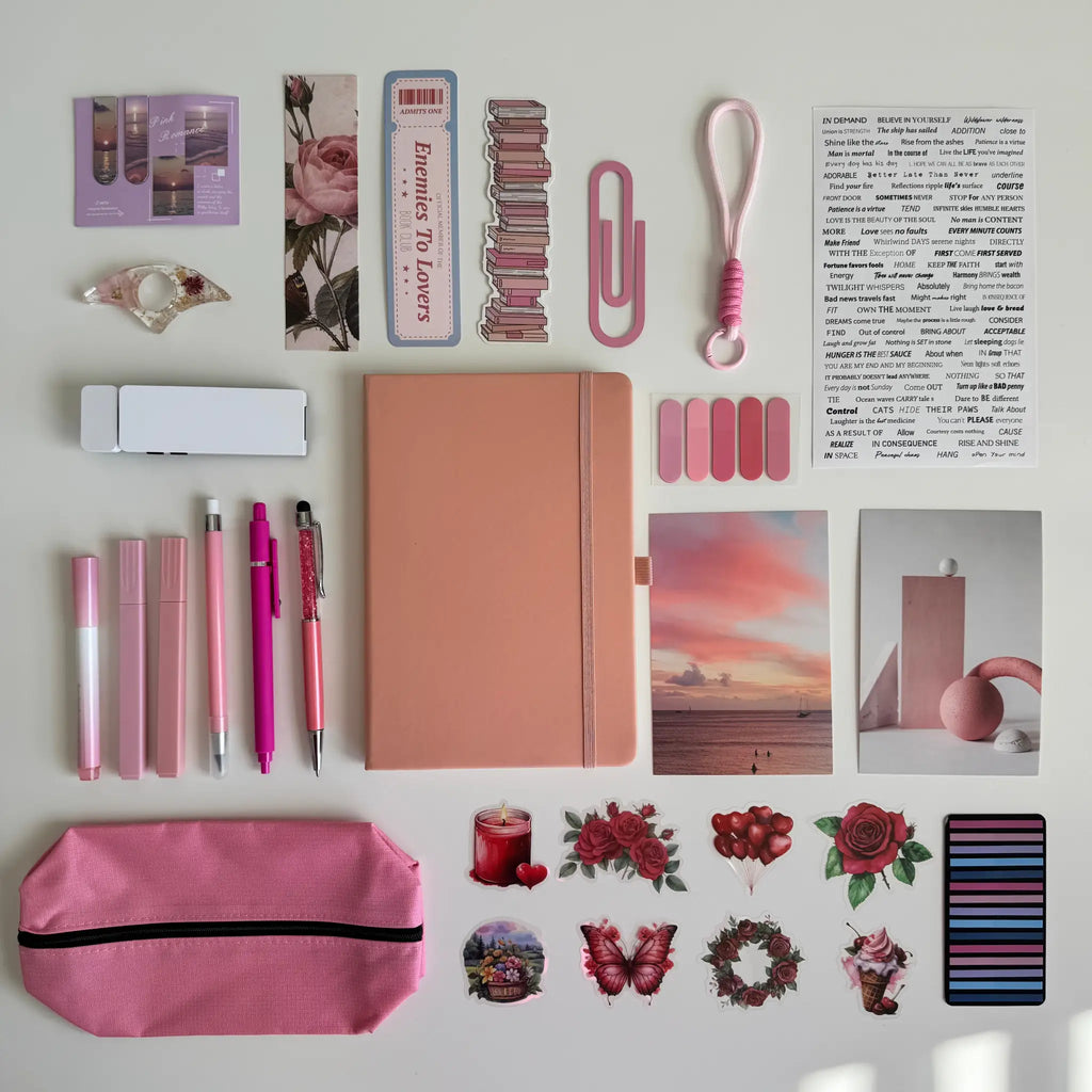 Collection of stationery items including a notebook, pens, and stickers on a light background