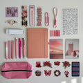 Collection of stationery items including a notebook, pens, and stickers on a light background