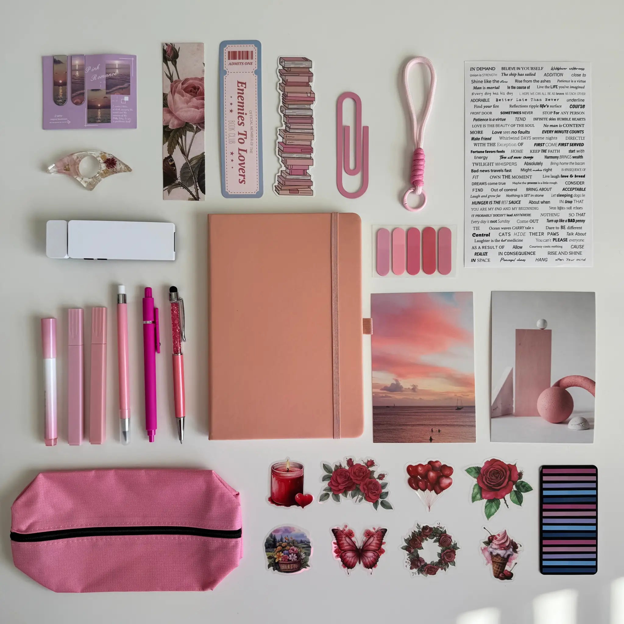 Collection of stationery items including a notebook, pens, and stickers on a light background
