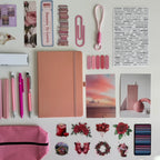 Collection of stationery items including a notebook, pens, and decorative stickers on a white background.