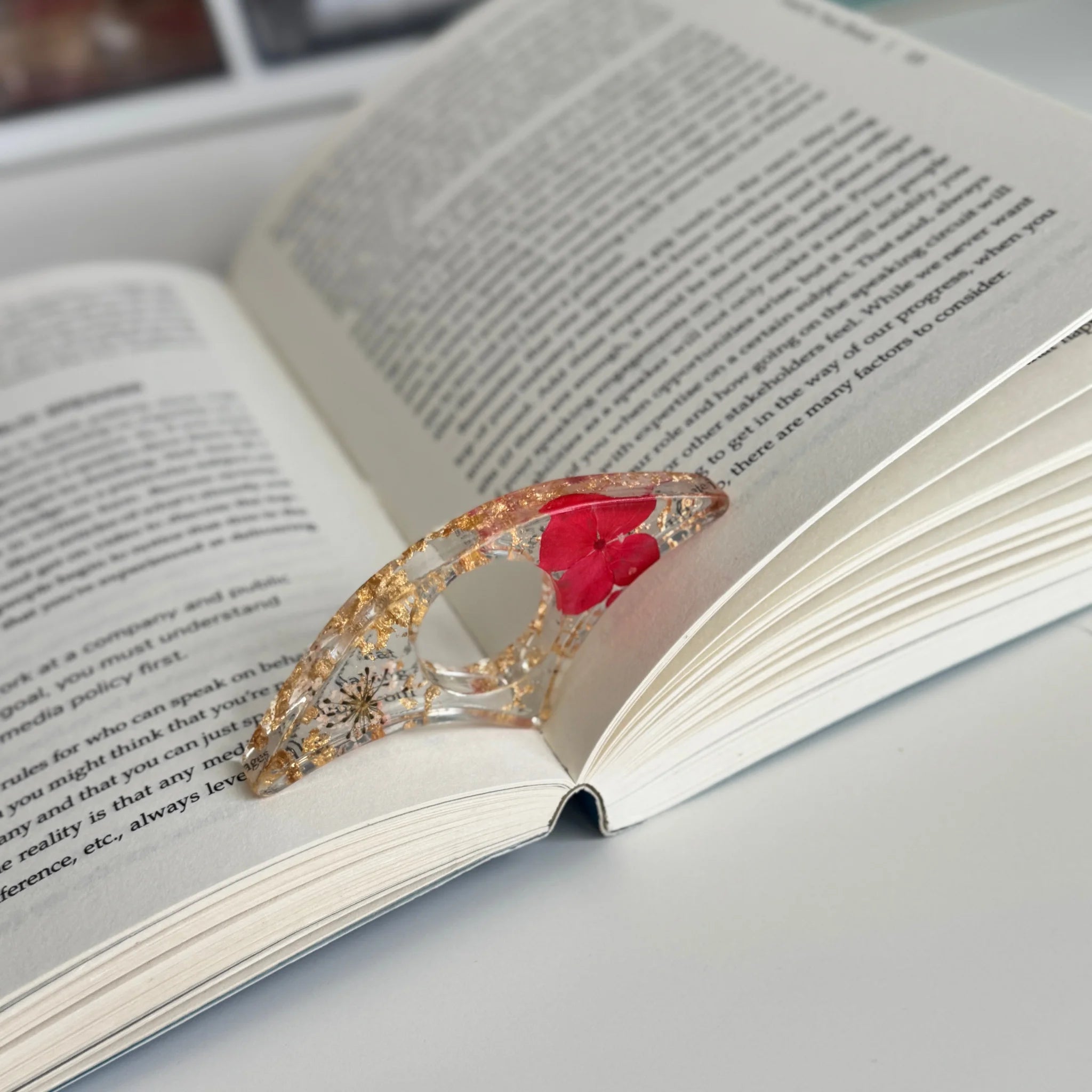 Decorative book holder with red flower on an open book