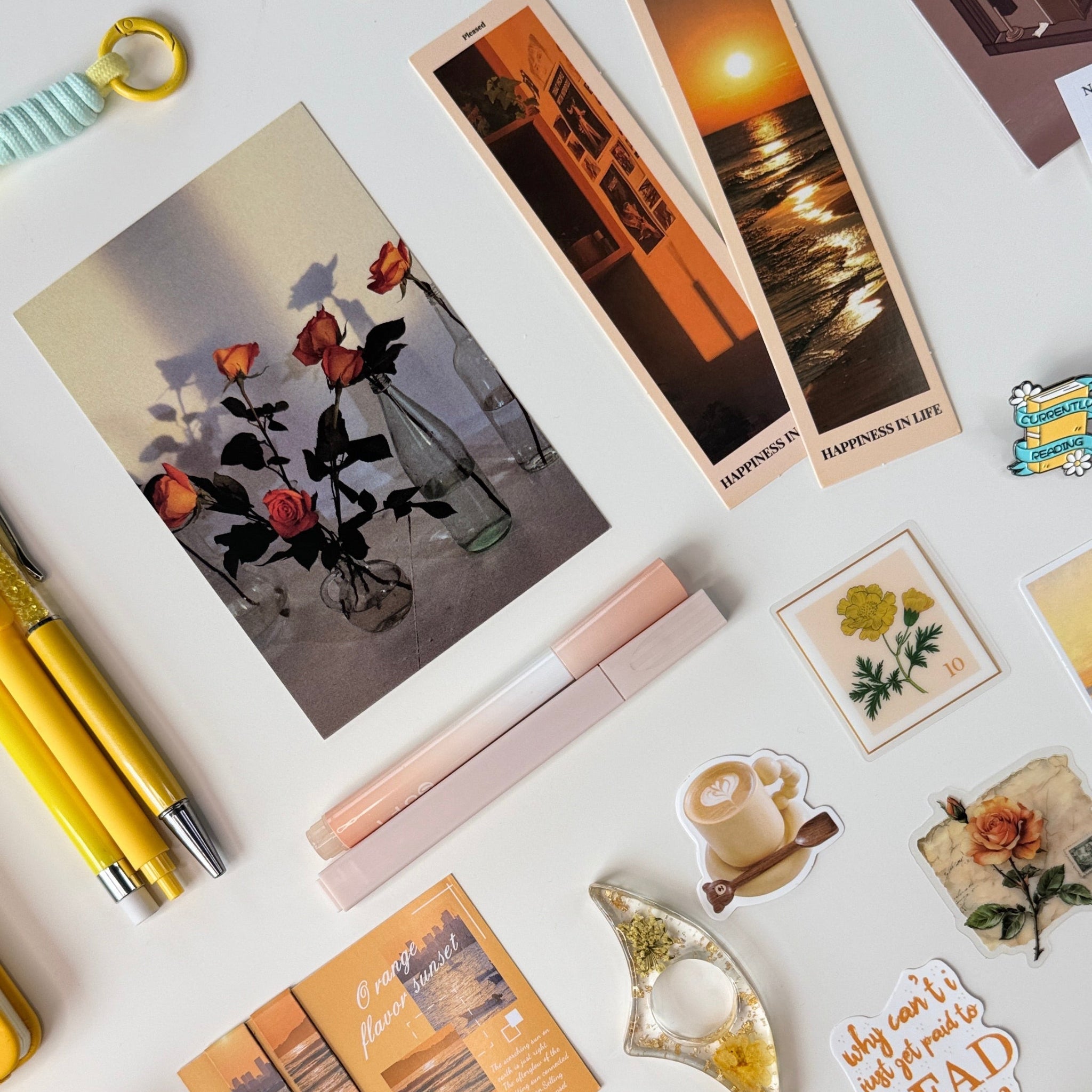 Collection of stationery items including bookmarks, stickers, and pens on a white surface.