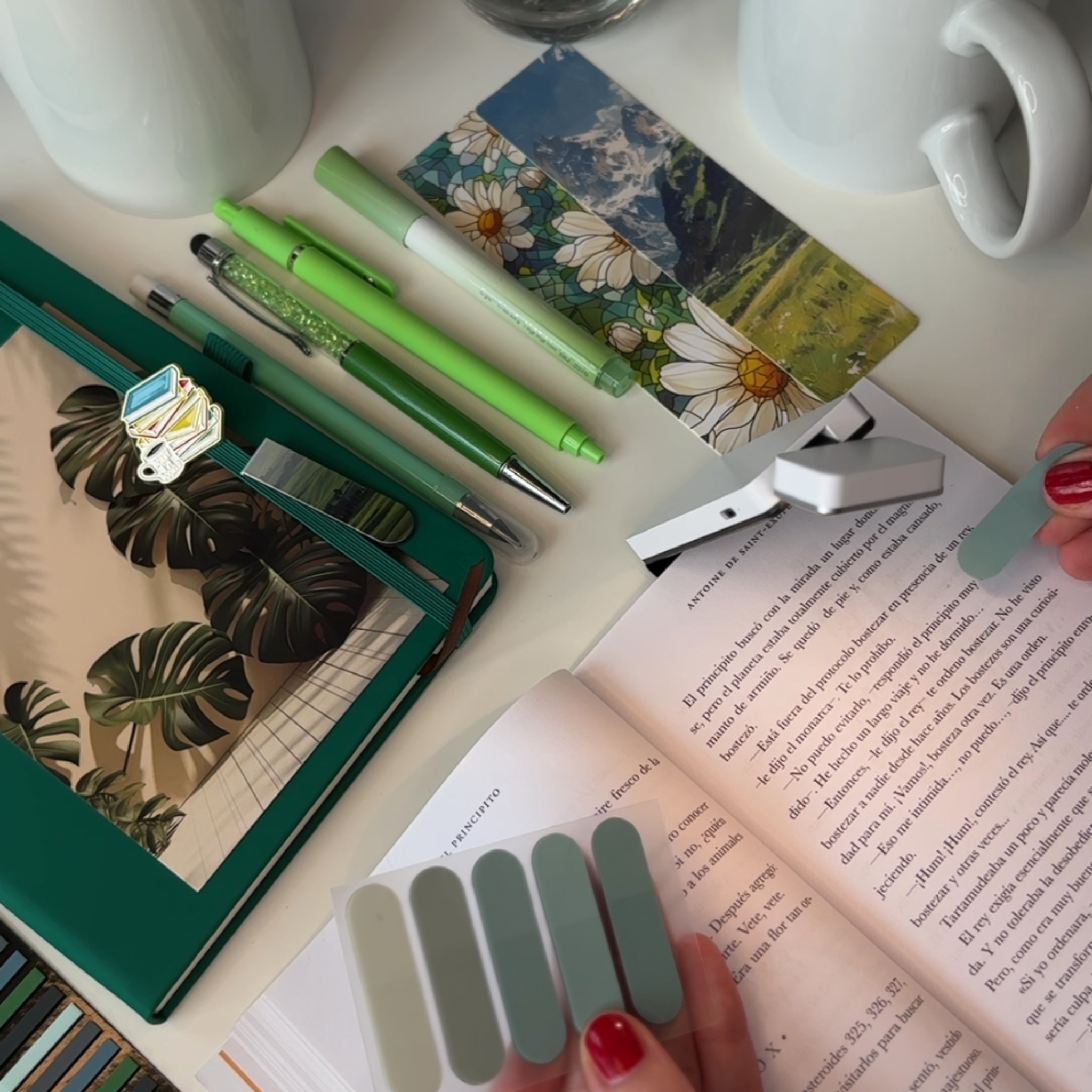 Desk with stationery items including pens, a mug, and a book.