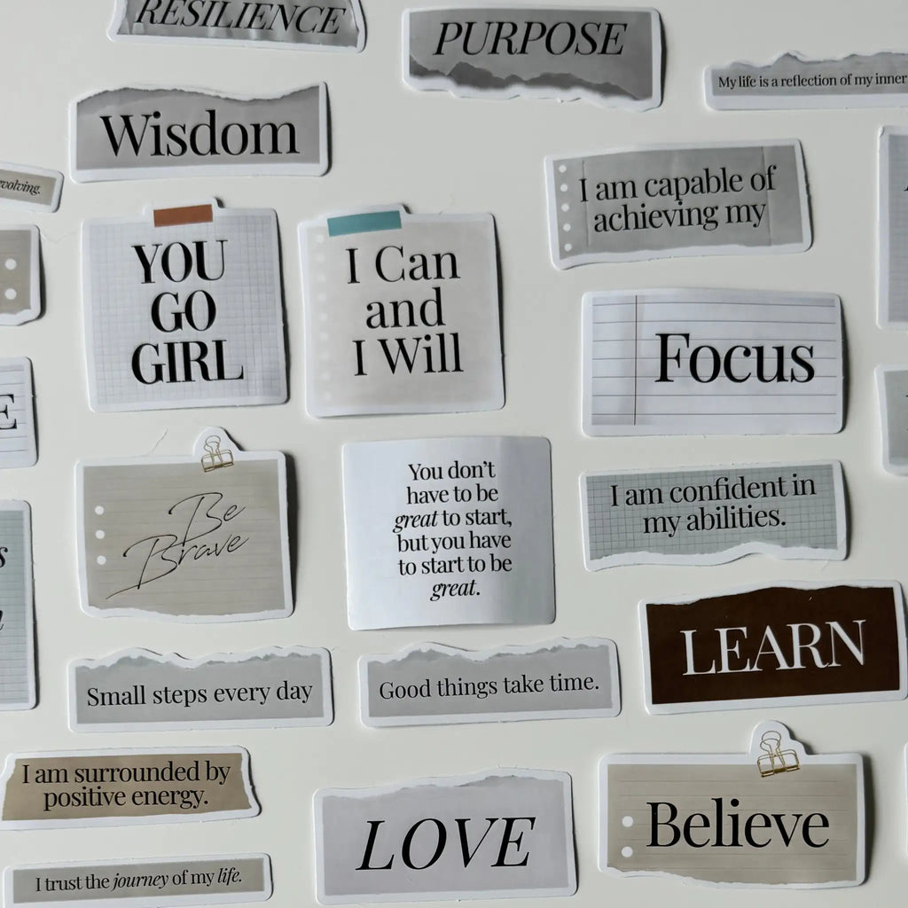 Motivational phrases on small cards attached to a white board.
