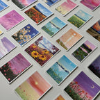 Collection of small cards with various scenic illustrations on a flat surface