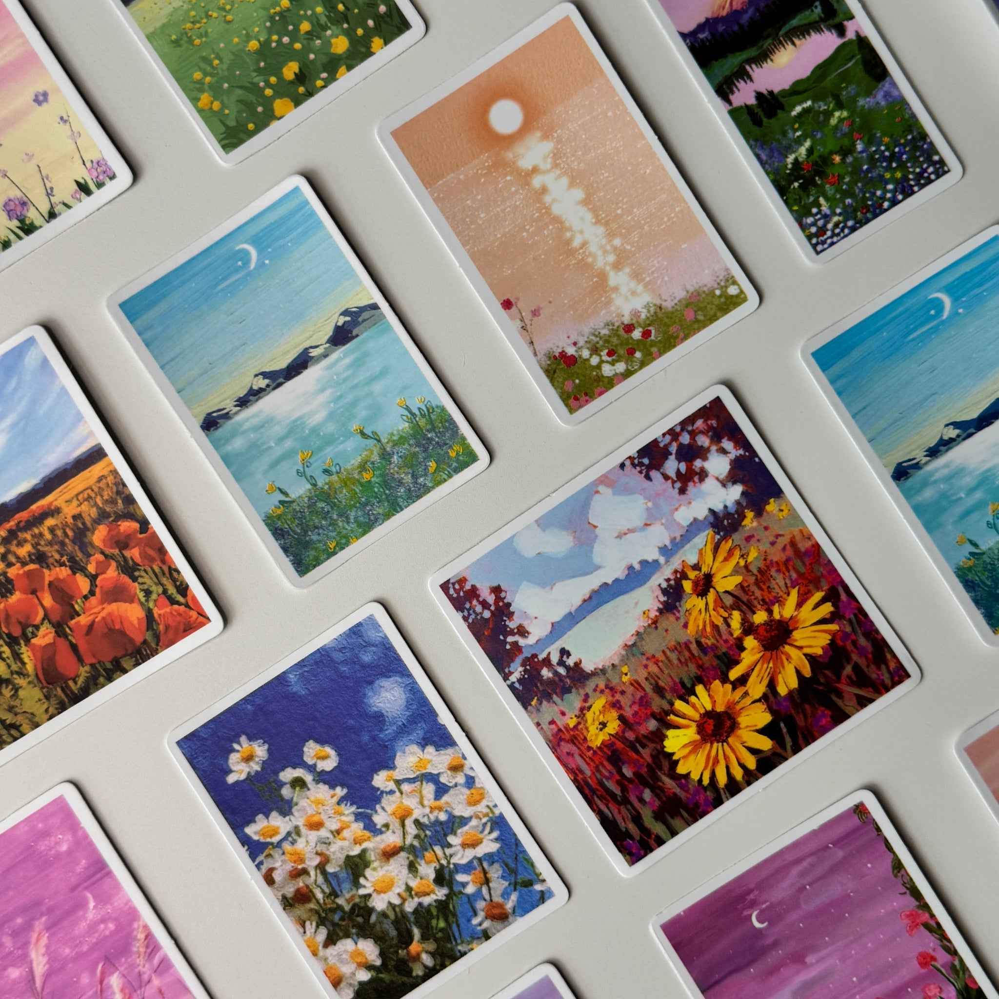 Collection of small painted cards depicting various landscapes and scenes.