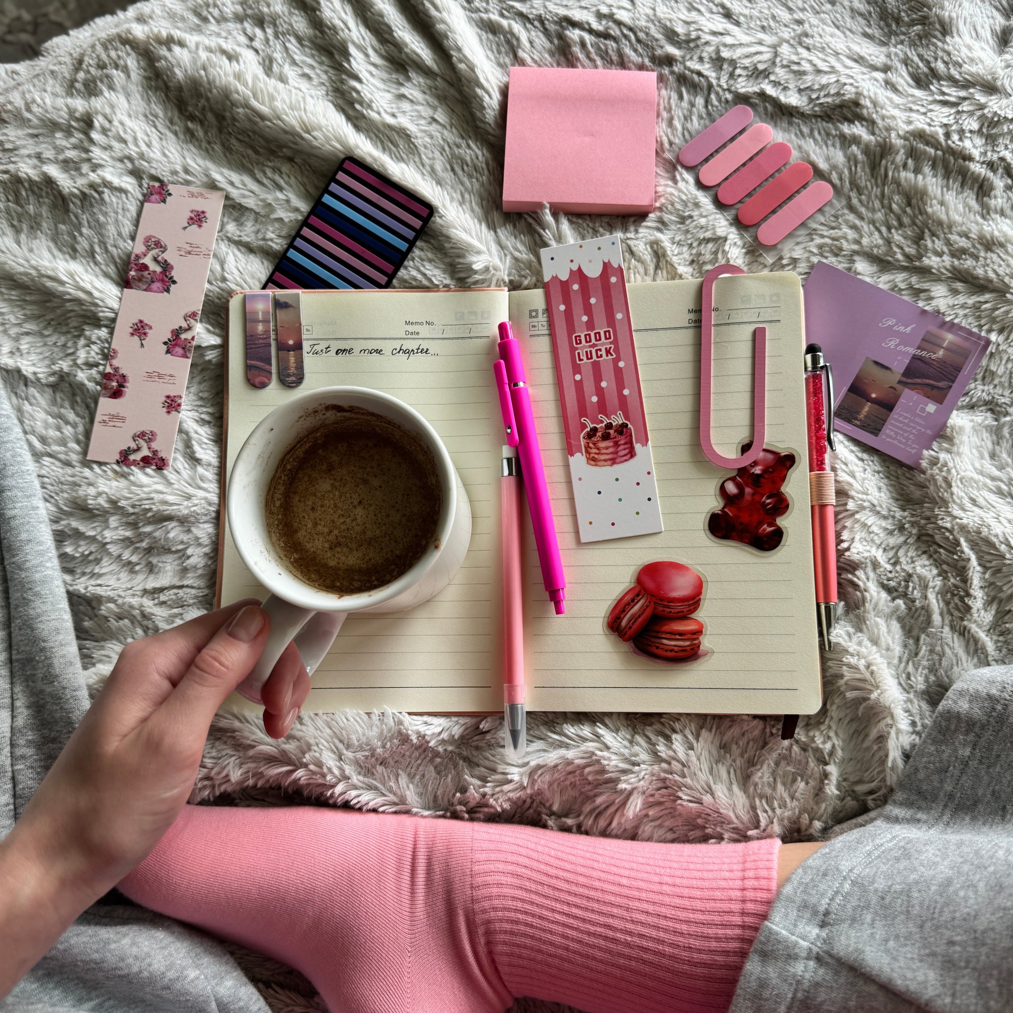 Notebook with stationery items and a cup of coffee on a textured surface