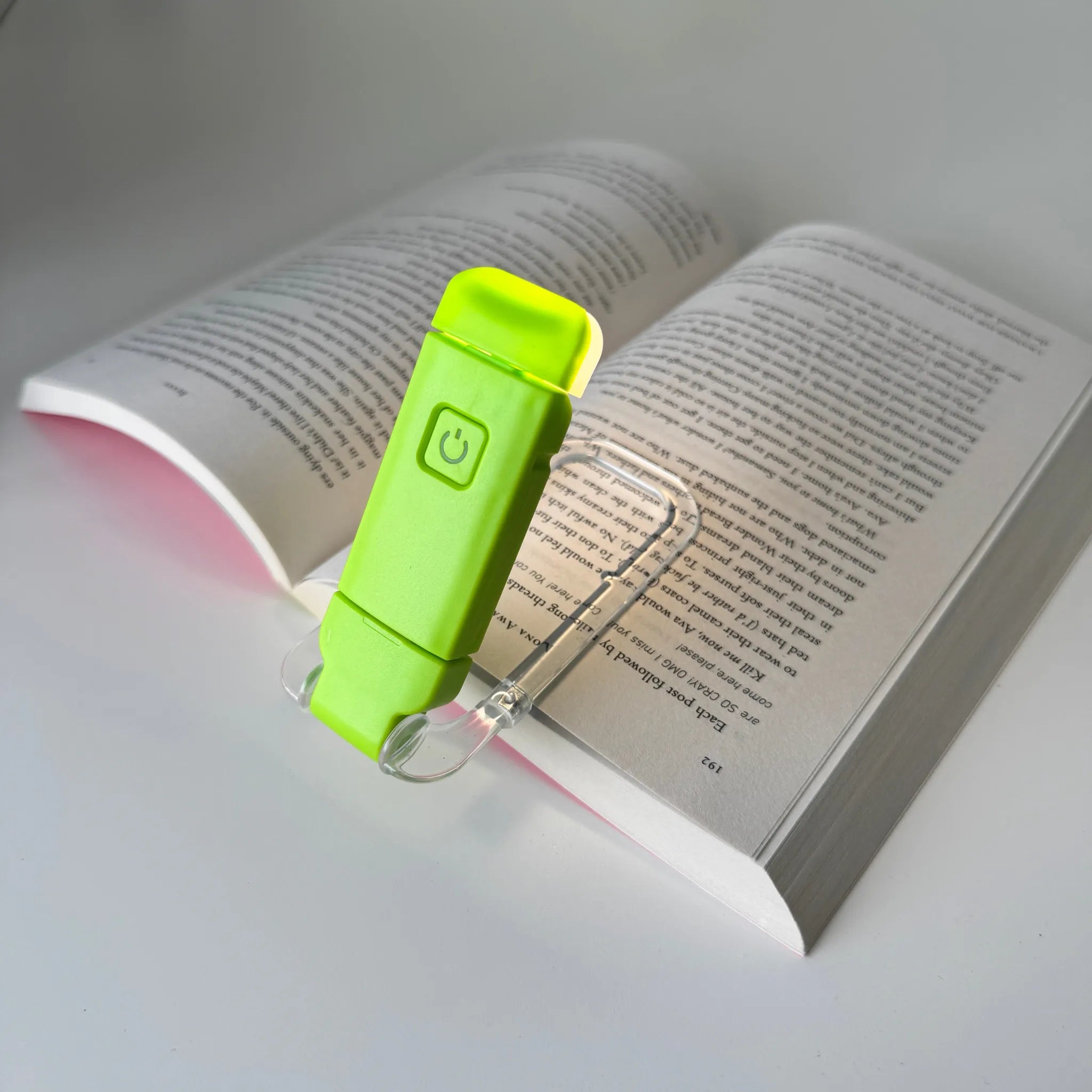 Green book light on an open book with a soft focus background