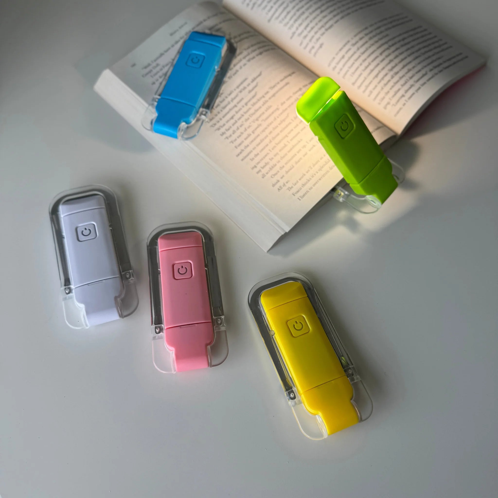 Colorful flashlight clip-on devices on an open book