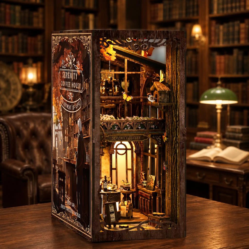 Detailed model of a coffee house inside a wooden box with a vintage bookshelf background.