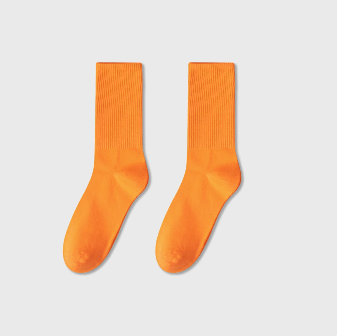 Pair of orange socks on a light gray background