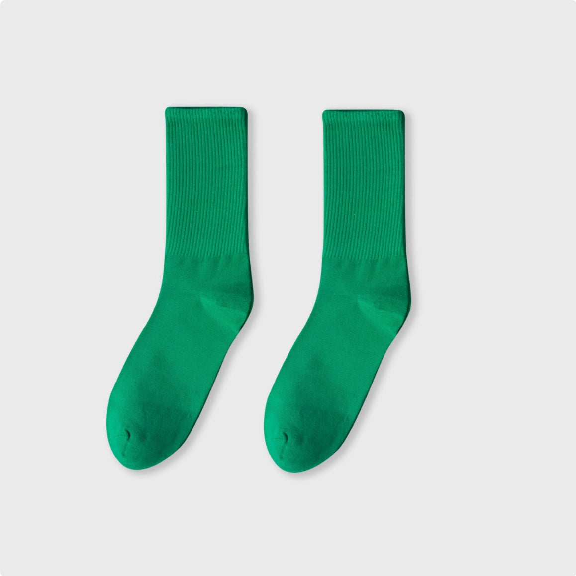 Pair of green socks on a light gray background