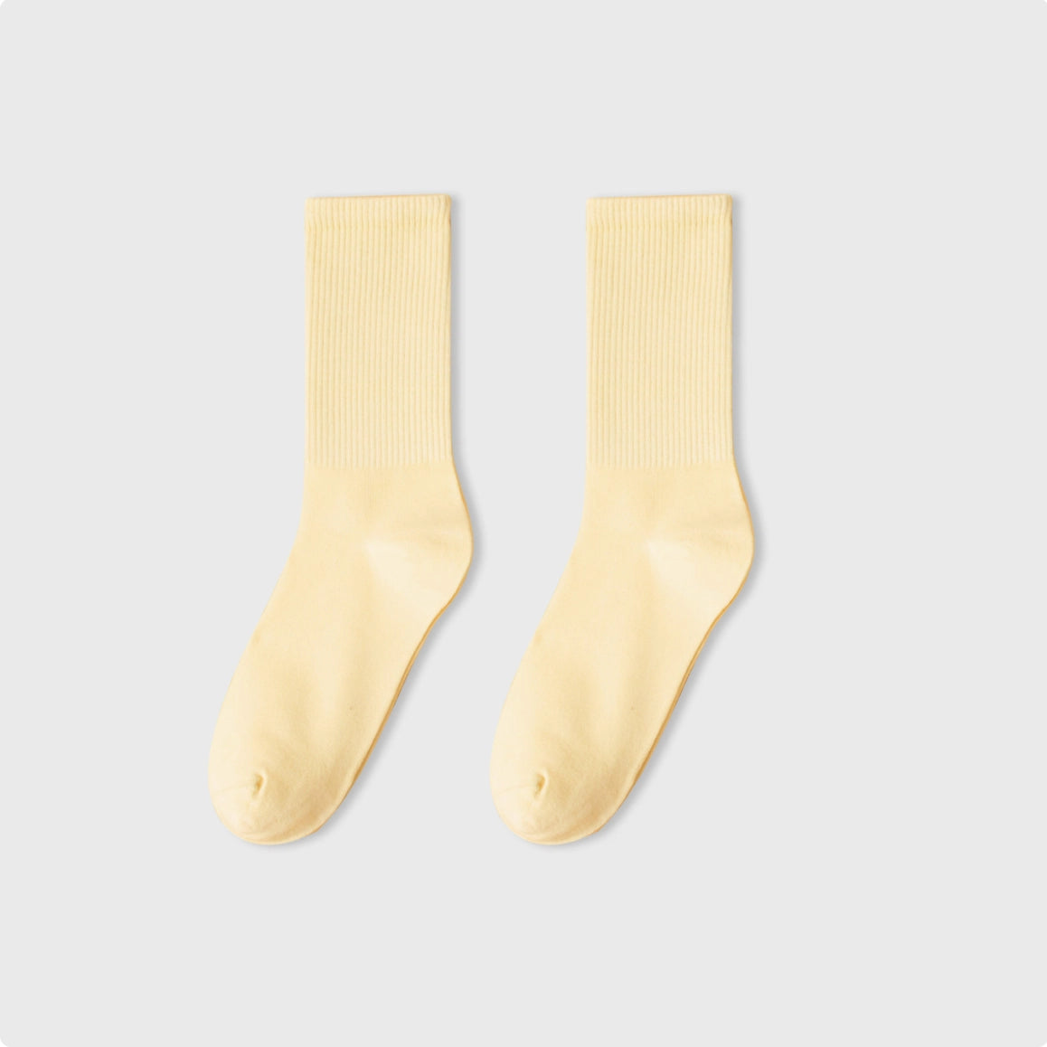 Pair of beige socks on a light gray background