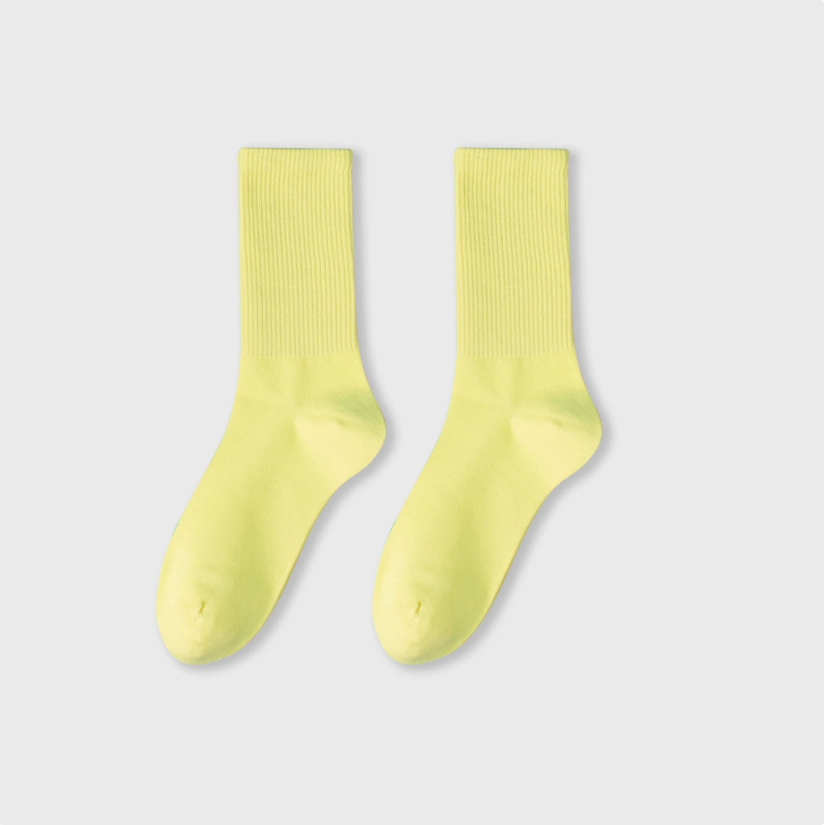Pair of light yellow socks on a light gray background