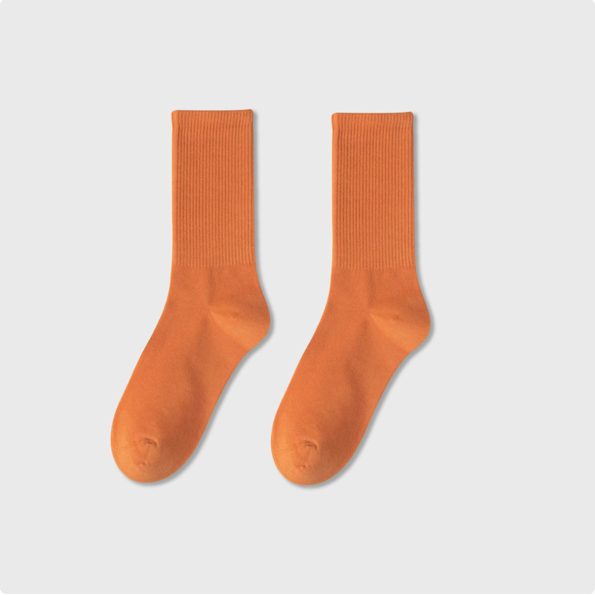 Pair of orange socks on a light gray background