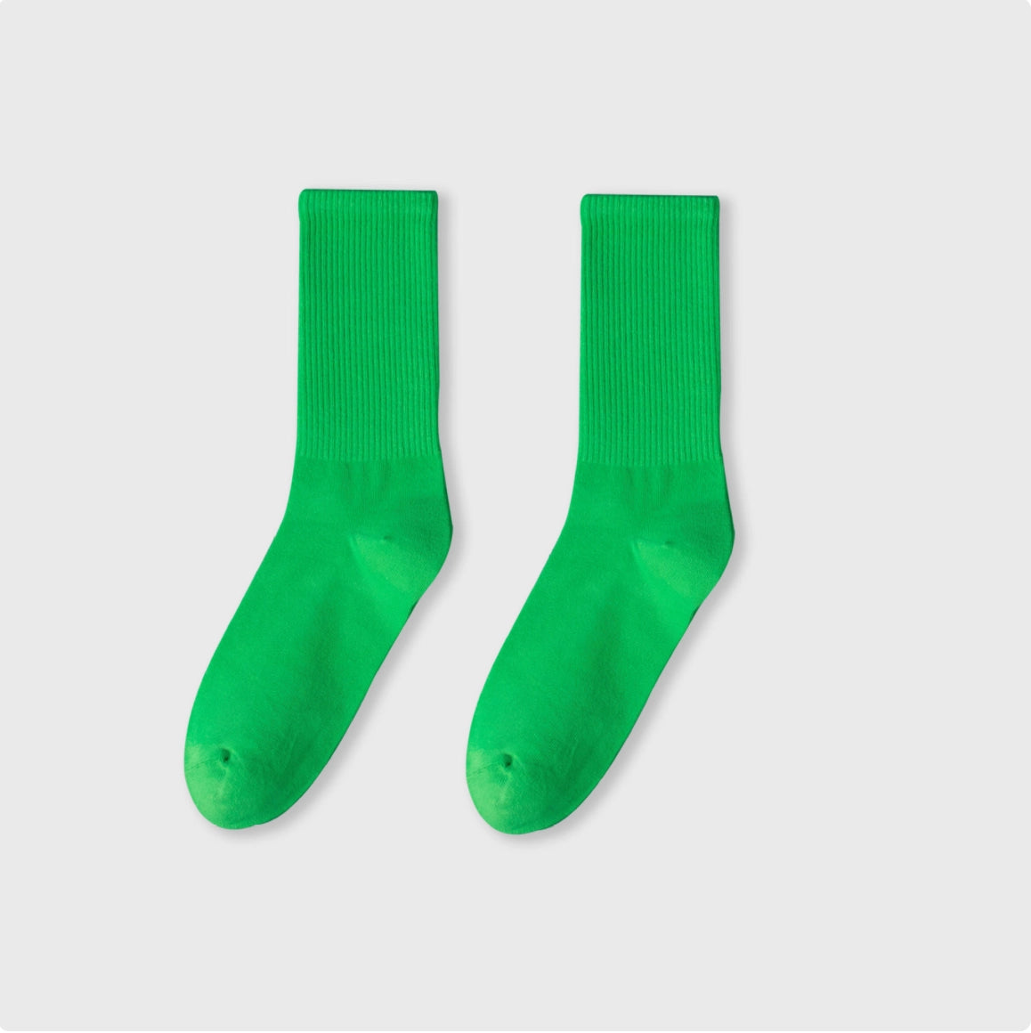 Pair of green socks on a light gray background