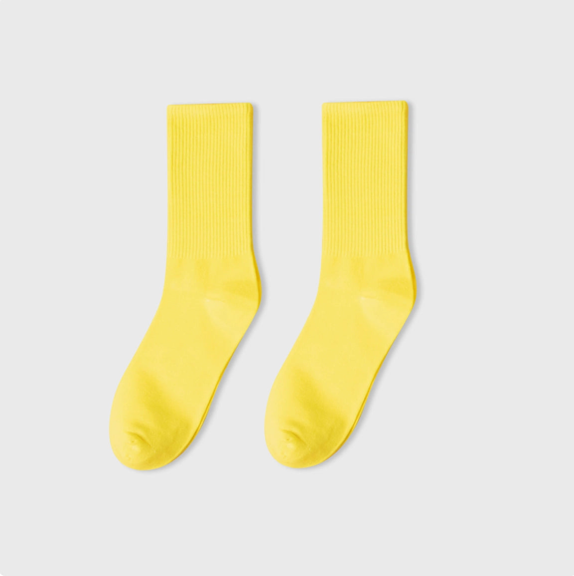 Pair of yellow socks on a light gray background