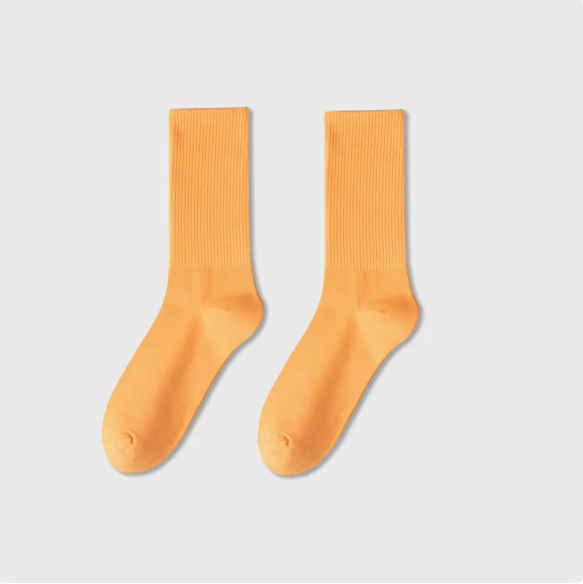 Pair of orange socks on a light gray background